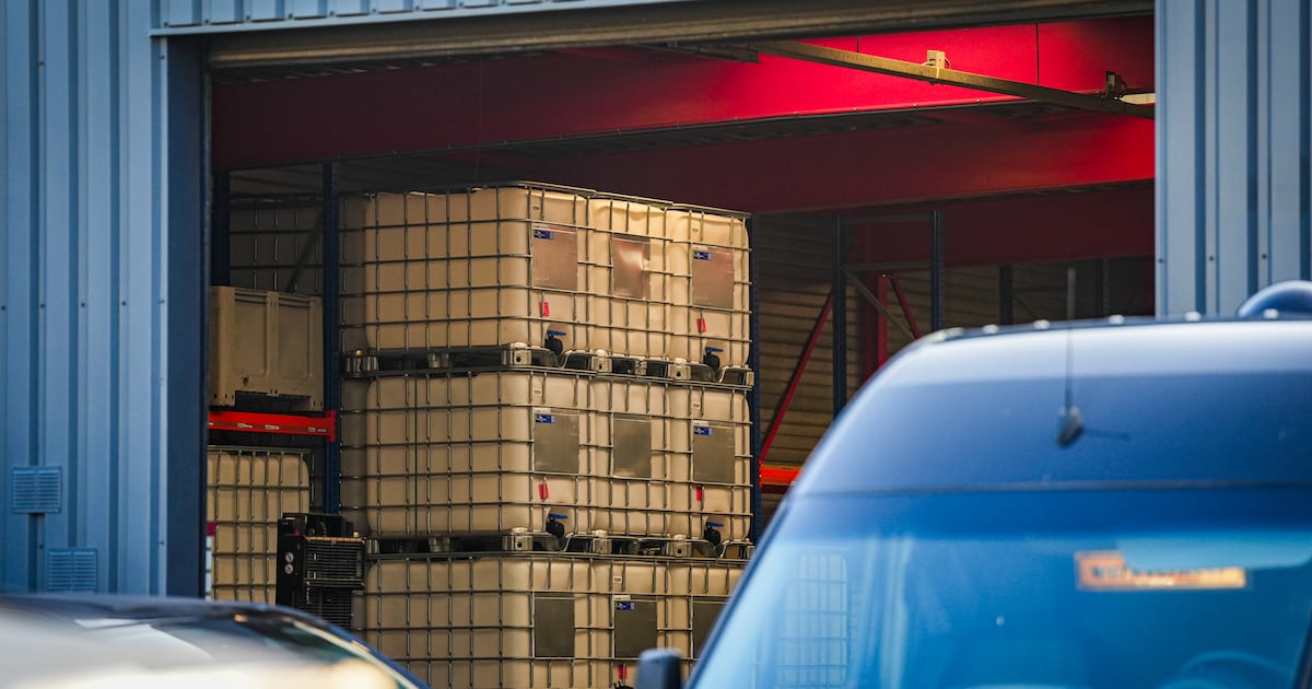 Inval bij Eindhovens transportbedrijf: zwaarbewapende agenten houden de wacht, grote vaten en kratte