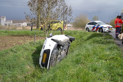 Auto belandt op zijkant in de sloot na botsing in Den Bosch