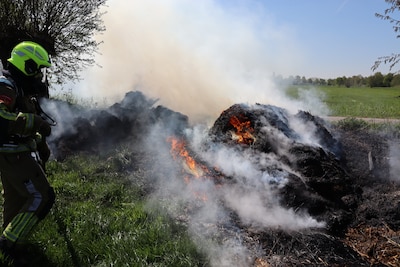 Berg met gemaaid gras vat vlam in Kaatsheuvel, brandweer harkt smeulende delen uit elkaar