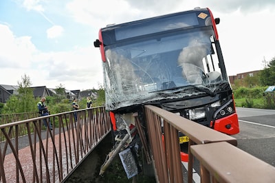 Bus ramt hek in Tilburg: enorme ravage, voertuig bungelt boven afgrond