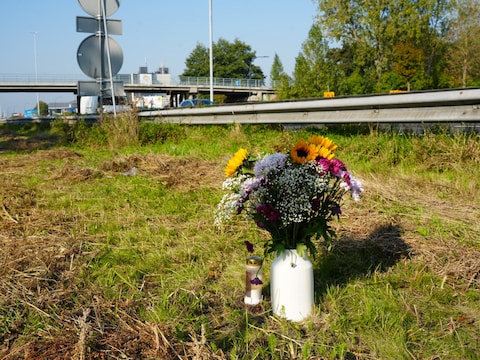 Een bos bloemen en een kaarsje op de plek des onheils. Op de achtergrond is te zien hoe dichtbij het viaduct was.  