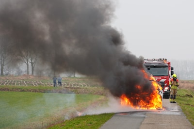 Mannen stappen op tijd uit Jeep, vlak voor auto in lichterlaaie staat bij Waspik