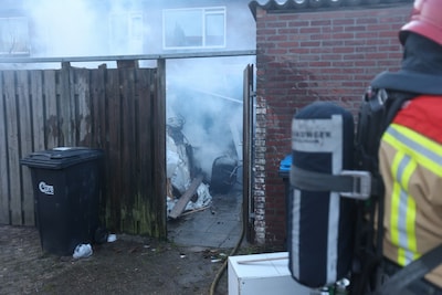 Bouwmateriaal vliegt in brand in Eindhovense achtertuin, gat in schutting gebrand